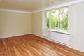 Empty bright room with a wooden floor and light wallpaper. The apartment is after renovation. Royalty Free Stock Photo