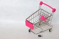 Empty and broken supermarket cart with a falling wheel on a white background. The crisis in the trade. Decline in purchasing power Royalty Free Stock Photo