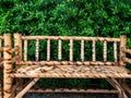 Empty brown bamboo wood bench with green leaves background. Royalty Free Stock Photo