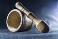 Empty brown mortar with a pestle wooden. A drinking bowl for crushing of spices. Black background. Kitchen utensils. Ware.