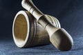 Empty brown mortar with a pestle wooden. A drinking bowl for crushing of spices. Black background. Kitchen utensils. Ware.