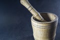 Empty brown mortar with a pestle wooden. A drinking bowl for crushing of spices. Black background. Kitchen utensils. Ware.