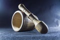 Empty brown mortar with a pestle wooden. A drinking bowl for crushing of spices. Black background. Kitchen utensils. Ware.