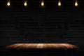Empty brown plank wood shelf at black modern tile wall background with light bulbs string,Mockup for display or montage of product