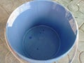 An empty bucket of liquid blue paint for coloring the walls.