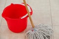 Empty bucket and mop on tile floor Royalty Free Stock Photo