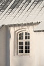 Empty building with ice damming on the roof on a cold winter day. The exterior of a home or house with snow on the Royalty Free Stock Photo