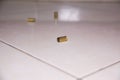 Empty bullet shells on the house floor. Bullet casings on the ceramic floor. selective focus Royalty Free Stock Photo
