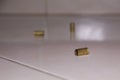 Empty bullet shells on the house floor. Bullet casings on the ceramic floor. selective focus Royalty Free Stock Photo