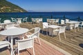 Empty cafe with chairs and tables by the seafront under a blue sky in summer Royalty Free Stock Photo