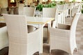 Empty cafe with rattan wicker armchairs and tables on summer garden.