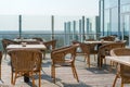 Empty cafe with rattan wicker armchairs and tables on summer garden terrace outdoor, free space. Table and chairs in empty cafe. Royalty Free Stock Photo