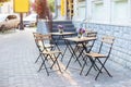 Empty cafe with terrace with tables and chairs. Street exterior of restaurant. Flowers in vase on table. Royalty Free Stock Photo