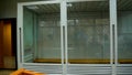 A cage with bulletproof glass for a suspect imprisoned in a courtroom. Panorama. Royalty Free Stock Photo