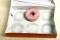 Empty cakes box with only one tempting and delicious donut with toppings left