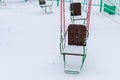 Empty carousels for children covered with snow in winter. Background with selective focus and copy space