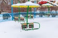 Empty carousels for children covered with snow in winter. Background with selective focus and copy space