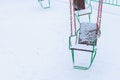 Empty carousels for children covered with snow in winter. Background with selective focus and copy space