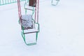 Empty carousels for children covered with snow in winter. Background with selective focus and copy space