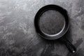 Empty cast iron frying pan on dark grey culinary background, view from above Royalty Free Stock Photo