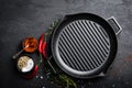 Empty cast-iron grill pan with ingredients for cooking on black background Royalty Free Stock Photo