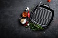 Empty cast-iron grill pan with ingredients for cooking on black background Royalty Free Stock Photo