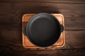 Empty cast iron round frying pan on textured wooden background close-up and copy space Royalty Free Stock Photo