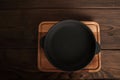 Empty cast iron round frying pan on textured wooden background close-up and copy space Royalty Free Stock Photo