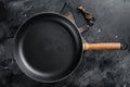 Empty cast-iron skillet for cooking on rustic towel. Black background. Top view. Copy space Royalty Free Stock Photo