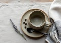 Empty ceramic cup on matching saucer placed on a light linen cloth beside scattered coffee beans Royalty Free Stock Photo