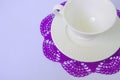 Empty ceramic cup and saucer on violet coaster Royalty Free Stock Photo