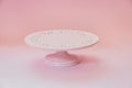 Empty ceramic pink cake stand on a pastel pink table