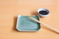 Empty ceramic plate and bamboo chopsticks with soy sauce Royalty Free Stock Photo