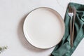 Empty ceramic plate, cutlery and cloth on a gray background. Eco concept. Top view Royalty Free Stock Photo