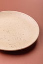Empty ceramic plate on a monochrome brown background Royalty Free Stock Photo