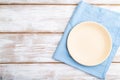 Empty ceramic plate on white wooden background and blue linen textile. Top view, copy space Royalty Free Stock Photo