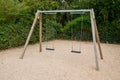 Empty chain swings wooden balance for children in garden park Royalty Free Stock Photo