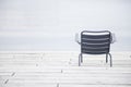 Empty chair on the beach in cloudy weather. Concept of loneliness, depression, emptiness and solitude Royalty Free Stock Photo