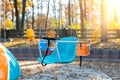 Empty chair multicolored colorful chain swing carousel at old vintage retro entertainment amusement park autumn sunset Royalty Free Stock Photo