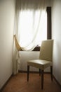 Empty chair by window with drapes. Royalty Free Stock Photo