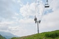 Empty chairlift in ski resort. Shot in summer with green grass and no snow. Cloudy weather. Royalty Free Stock Photo