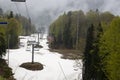 Empty chairlift in ski resort. Shot in summer with green grass and very little snow toned Royalty Free Stock Photo