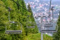 Empty chairlifts go up and down the mountain, village down in valley in background