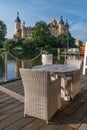 Empty chairs in cafe with a beautiful castle in Schwerin in the background.