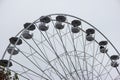 Empty chairs on Ferris wheel against cloudy sky. Close up telephoto detail shot, no people