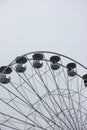 Empty chairs on Ferris wheel against cloudy sky. Close up telephoto detail shot, no people