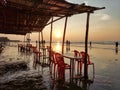 Empty chairs of Mandarmani beach tea stall,tourists enjoying sunrise.