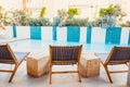 Empty chairs and rattan cube tables in lounge, rest zone with view on swimming pool and tropical plants flowerbed. Summer, travel