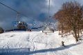 Empty chairs at station of ski-lift chair at resort Snowland Valca in winter season Royalty Free Stock Photo