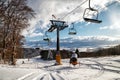 Empty chairs at station of ski-lift chair at resort Snowland Valca in winter season Royalty Free Stock Photo